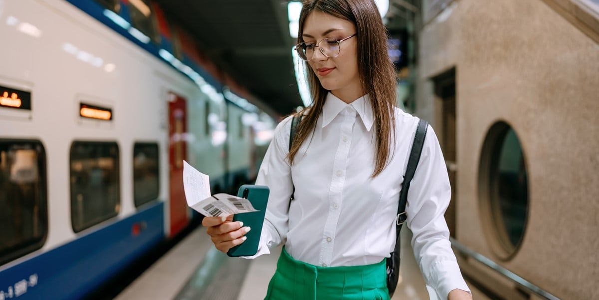 traveler looking at boarding pass, metro station