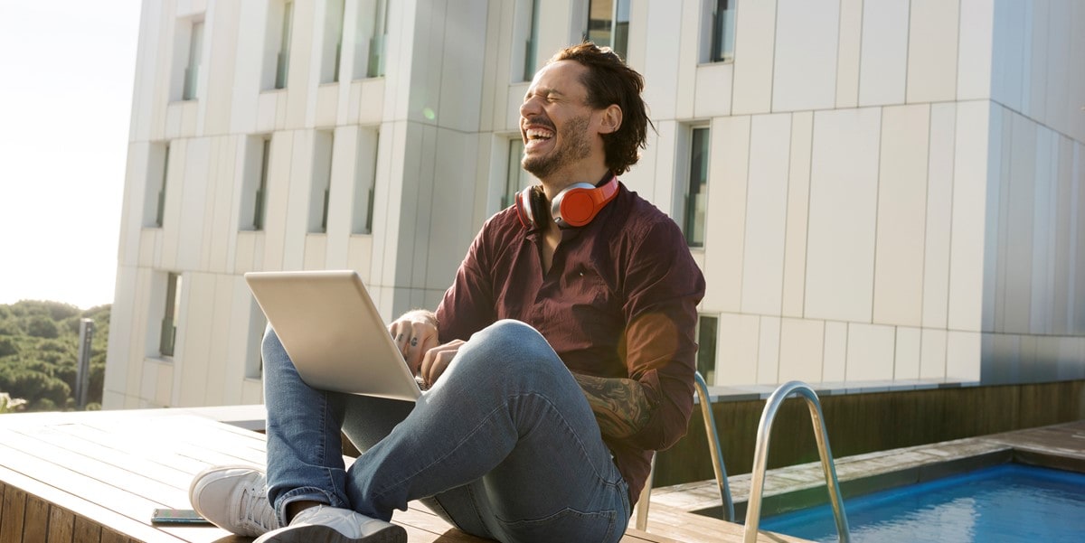 man sitting outside using laptop, city